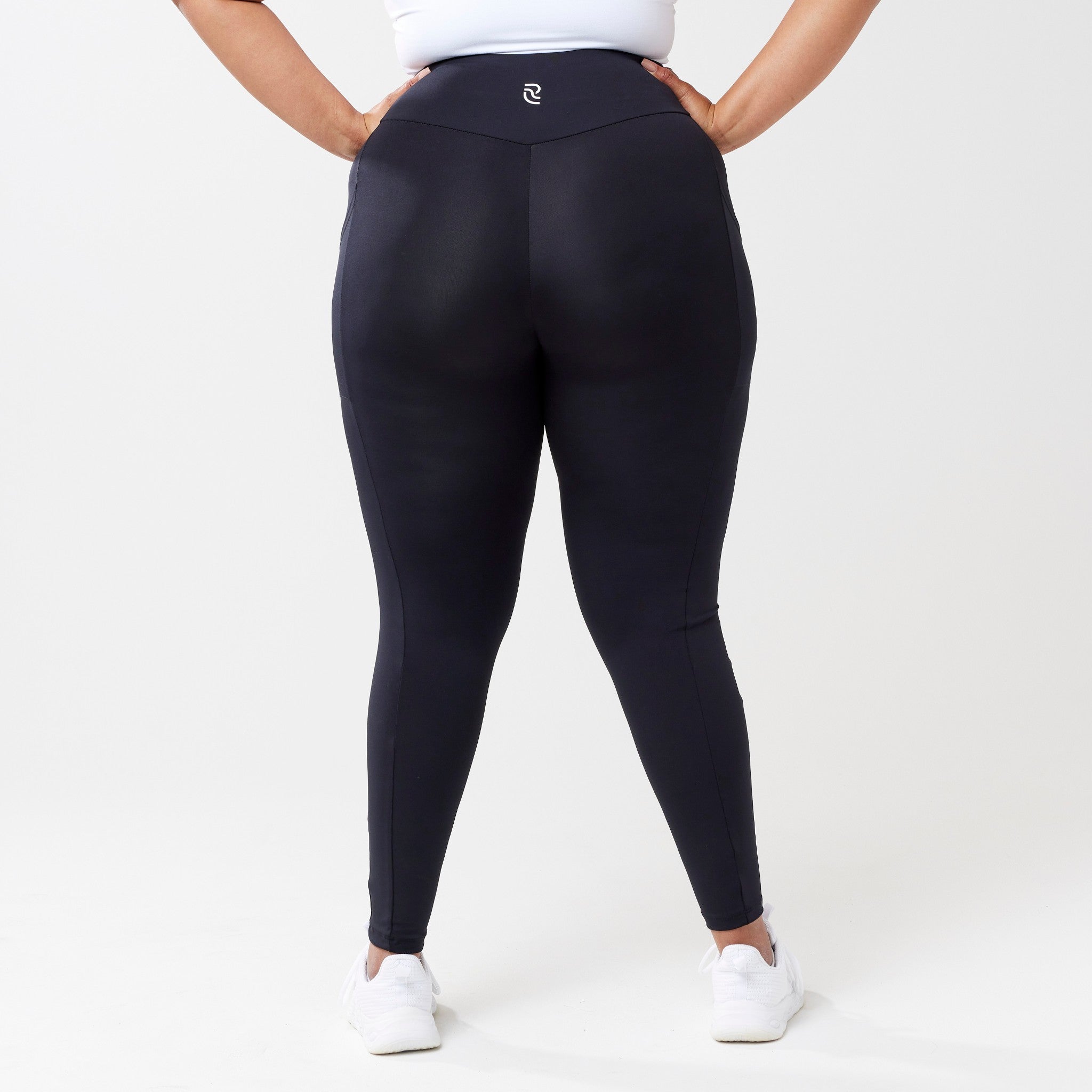 Plus model wearing black leggings for use in active lifestyles as well as casual living.